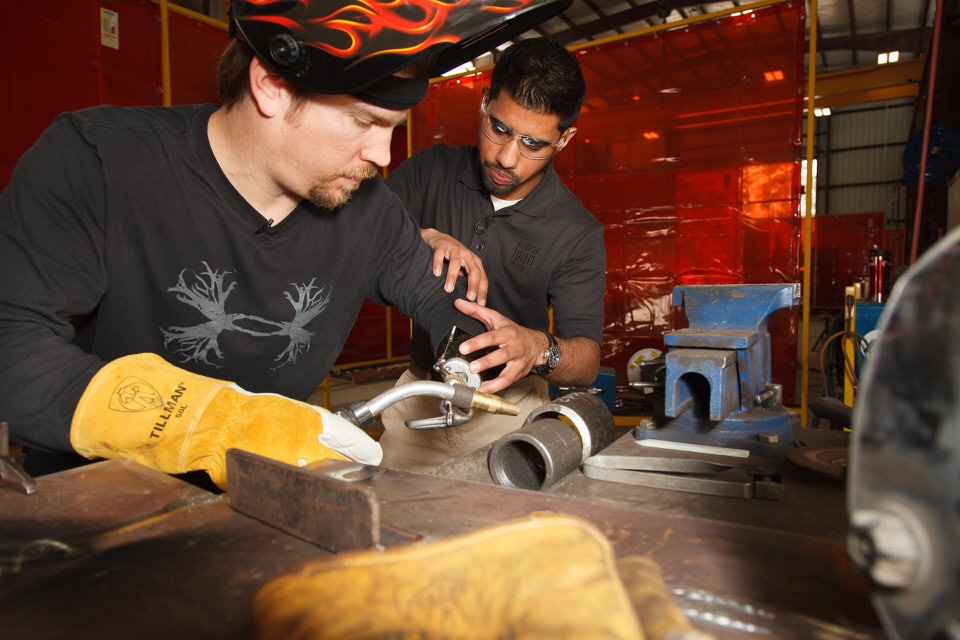 Upper Limb Occupational Therapist Joby Varghese helps Sky Carr position his body-powered prosthesis for welding