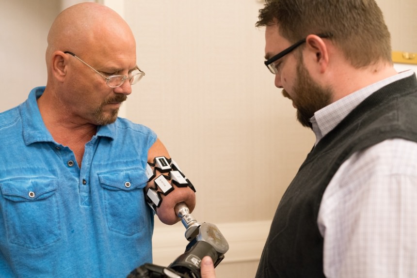 Arm Dynamics prosthetist speaking with an osseointegration amputee  at Arm Dynamics' upper limb prosthetic symposium event