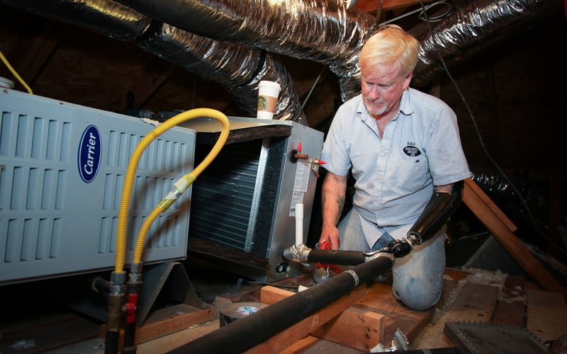 Gulf Coast patient Michael Dunn works on air conditioning unit in attic