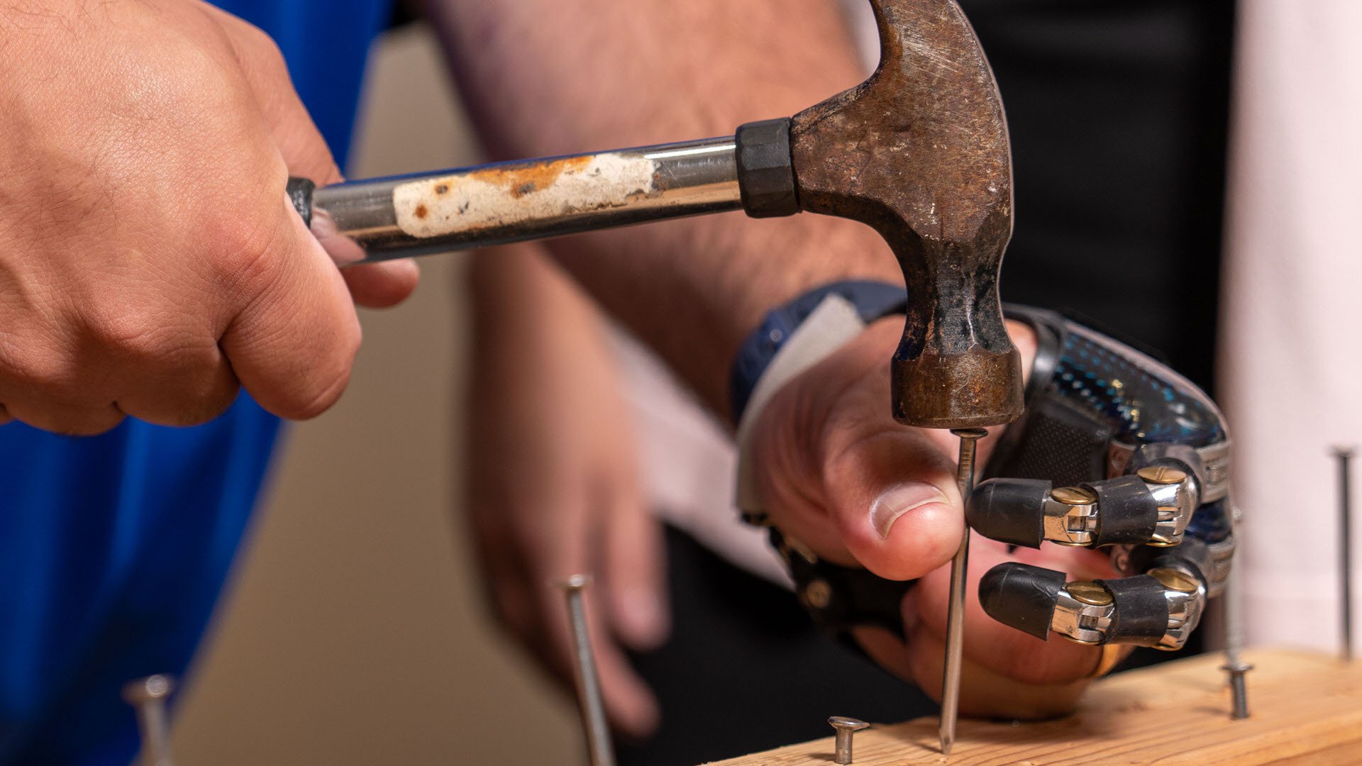 Point Designs Digits holding nail and hammering