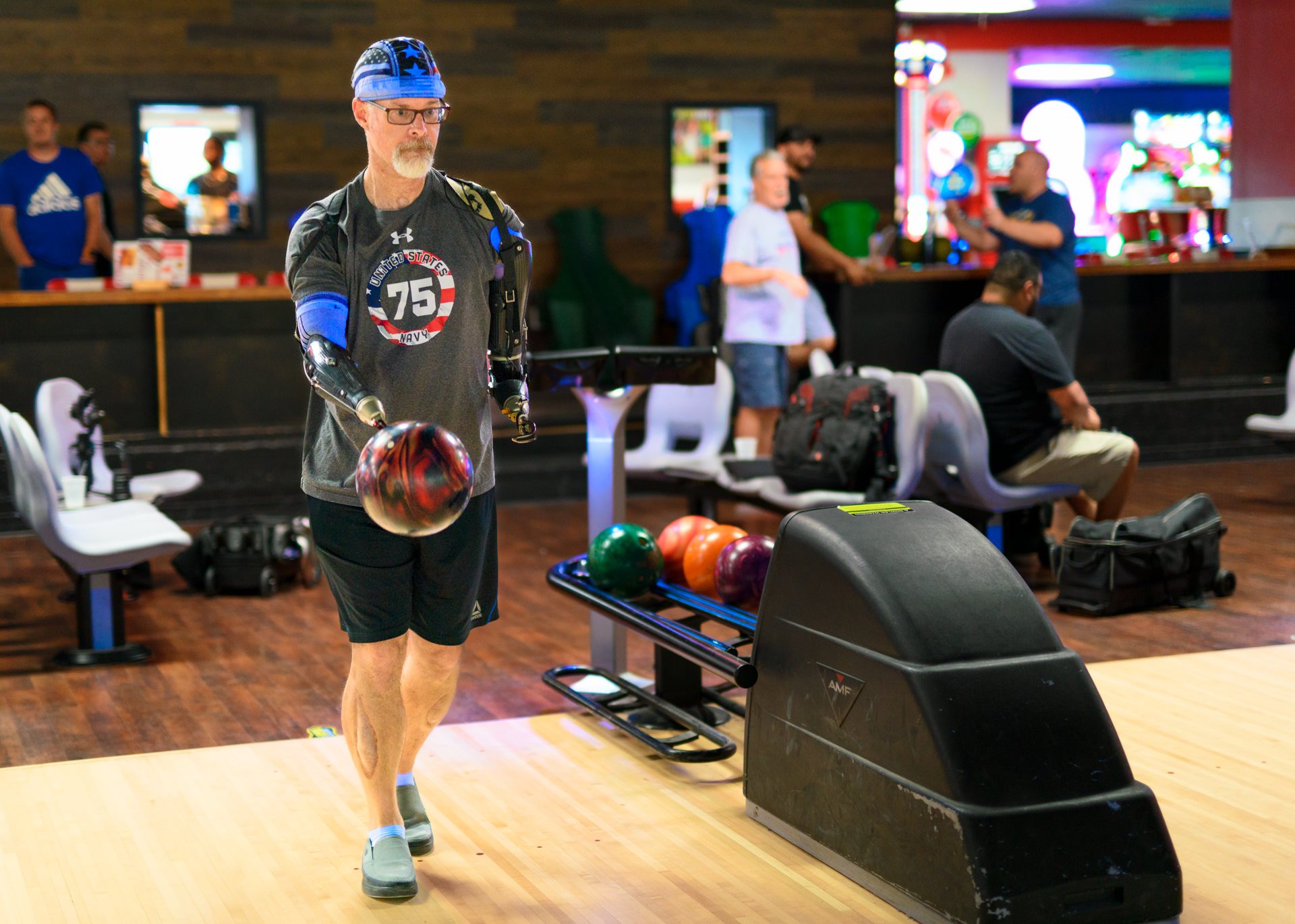 A bilateral transradial patient uses his bowling activity-specific prosthesis.