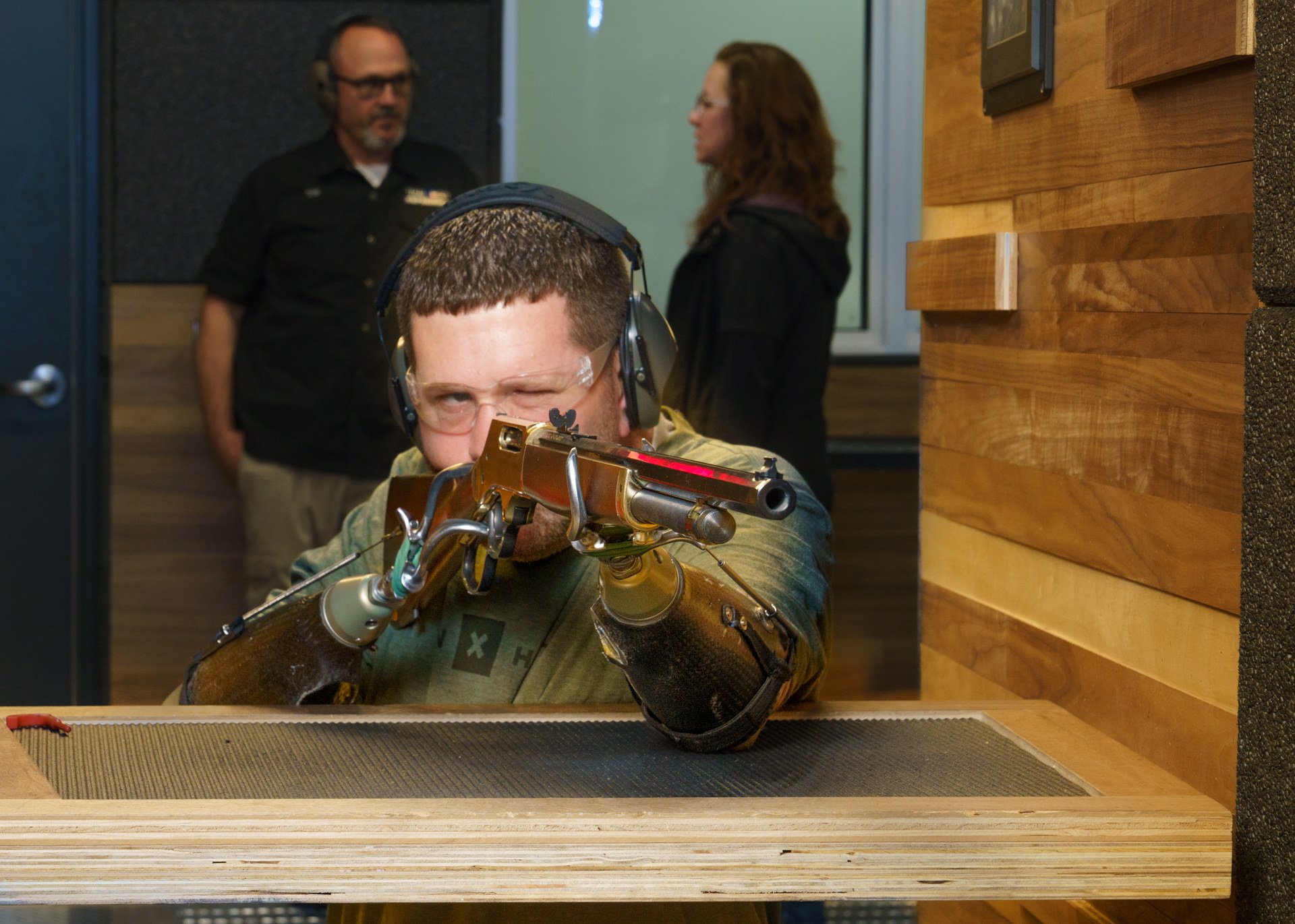 bilateral transradial patient, Jason Koger uses his body-powered hook prostheses to fire a gun at a gun range.