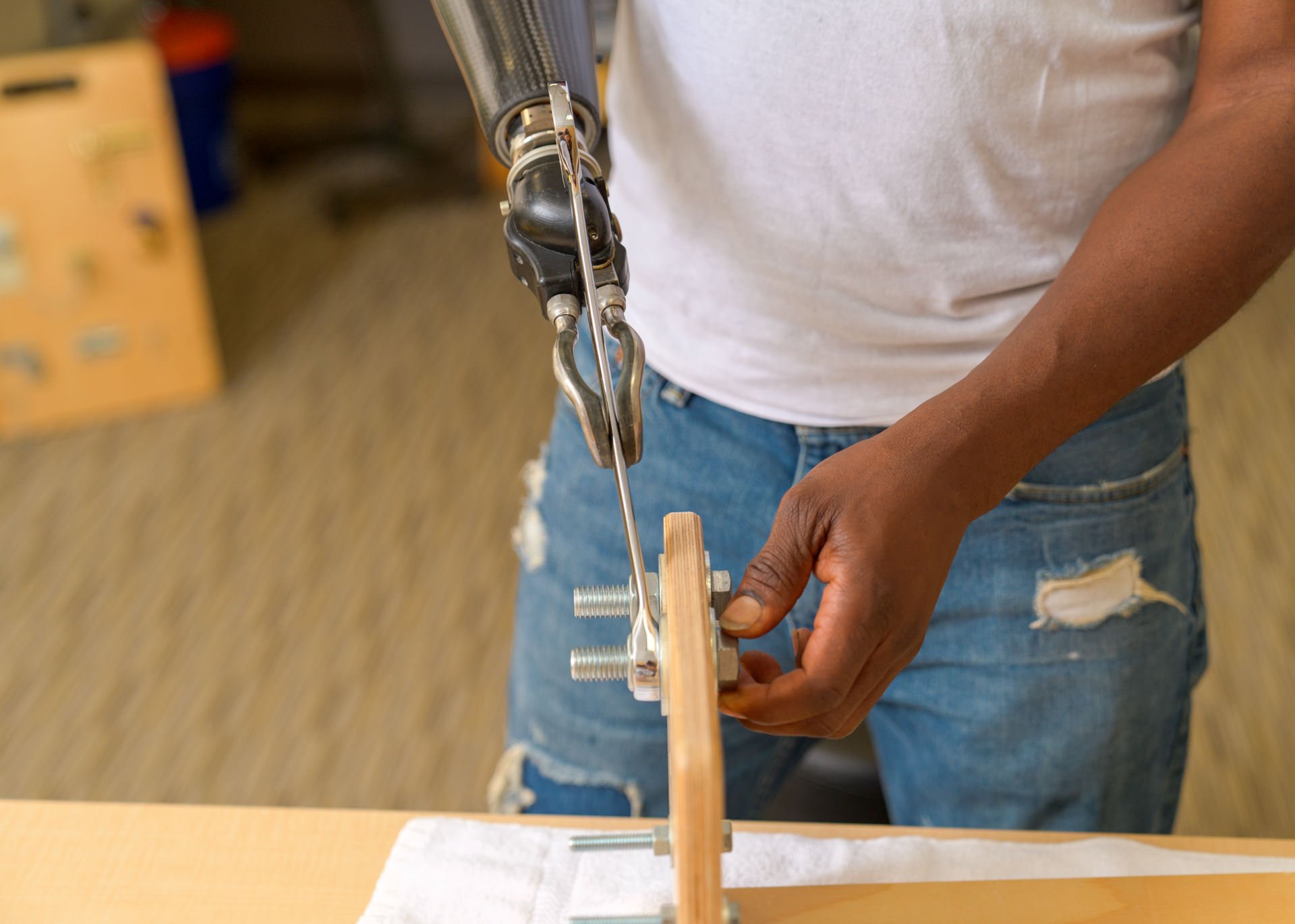 A transradial patient uses his electrically-powered ETD to hold a tool in a clinical therapy exercise.