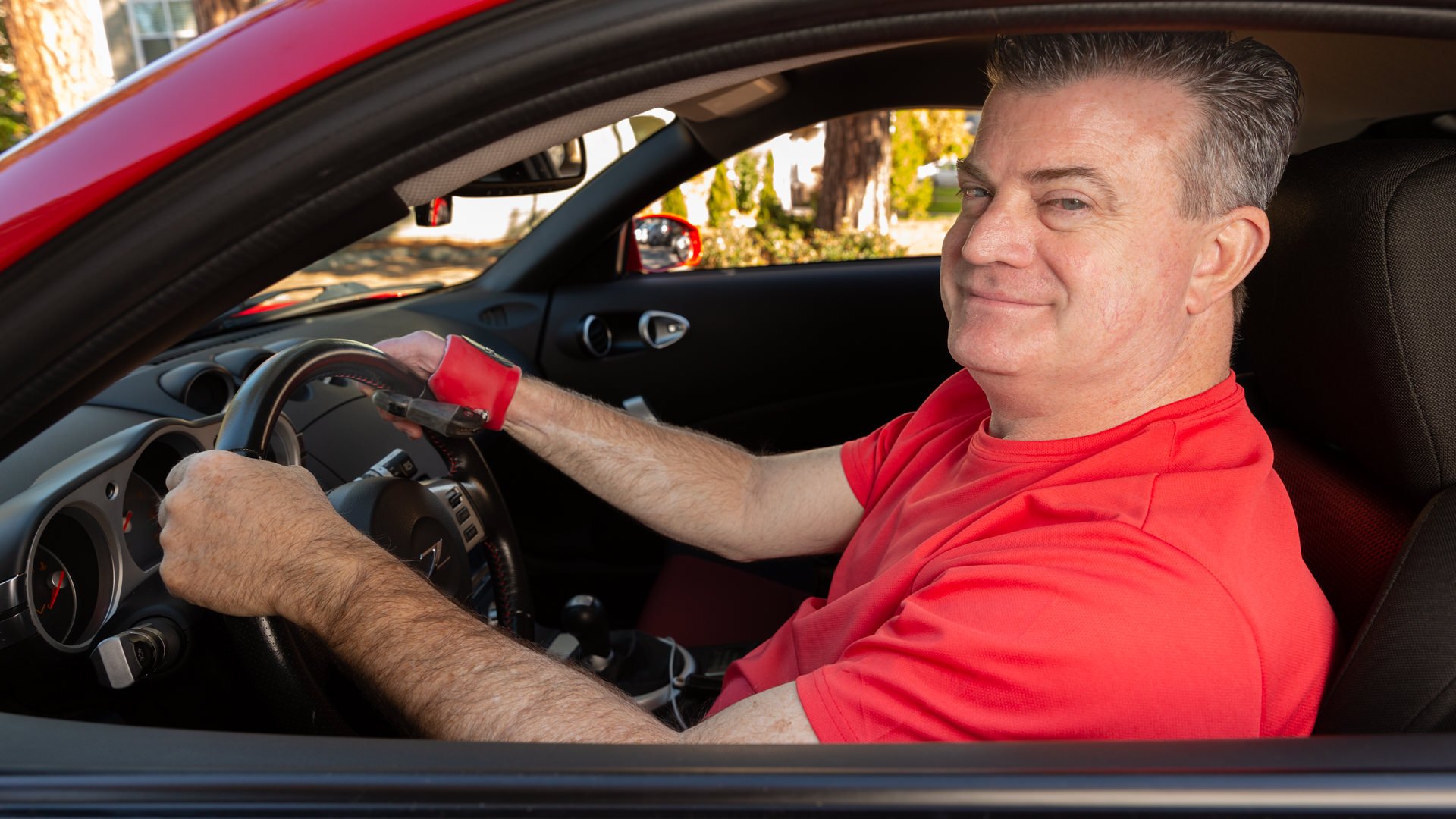 Dennis Roberts in his car using his prosthetic thumb