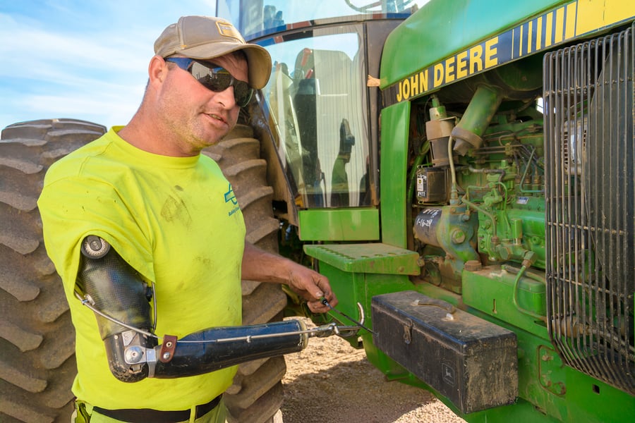 John Mitchell checking oil on tractor