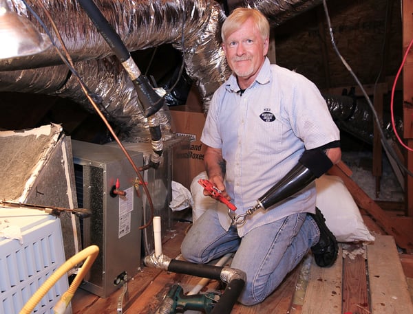 Michael Dunn working on AC unit in attic