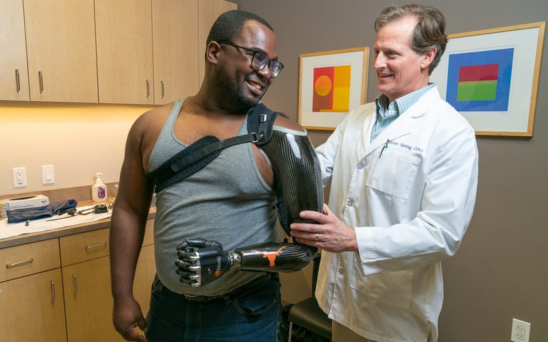 Gulf Coast center prosthetist Scott Spring works with shoulder level patient Lloyd Keith