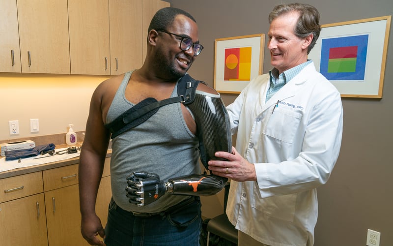 Gulf Coast center prosthetist Scott Spring works with shoulder level patient Lloyd Keith