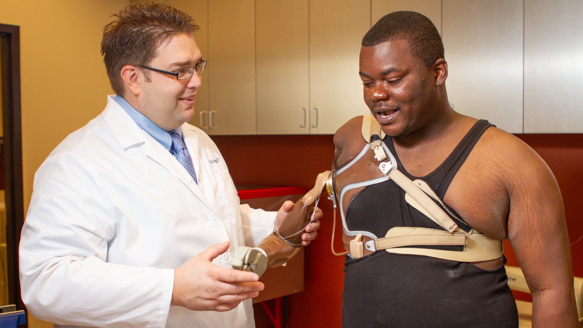 Patrick Prigge, CP, FAAOP(D) working with a patient wearing a hybrid prosthesis