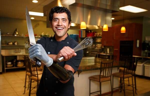 Eduardo Garcia in the kitchen with his i-limb hand