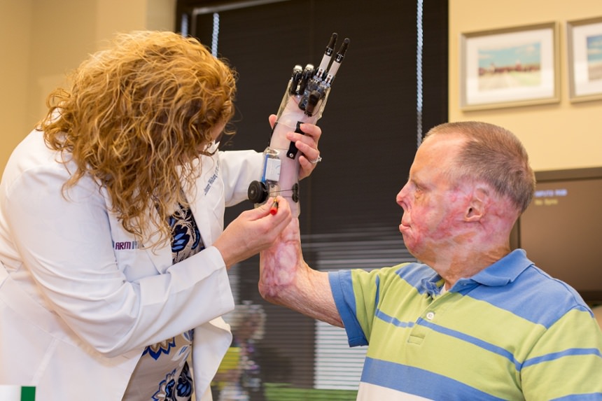 Therapist Lisa Wanters adjusts and checks alignment of the prosthesis