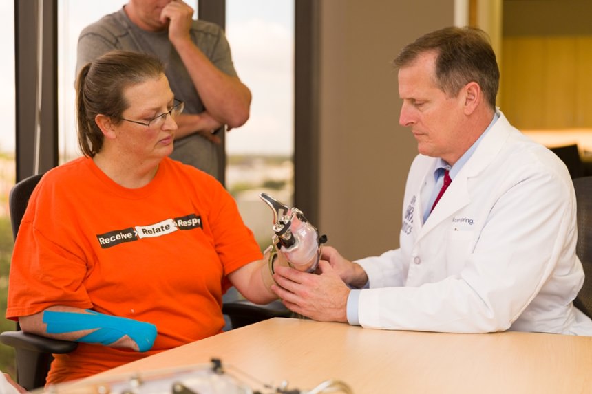 Prosthetist Scott Spring checks alignment of the prosthesis