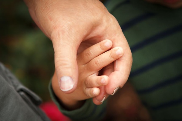 Arm Dynamics silicone restoration prosthesis holding a child's hand